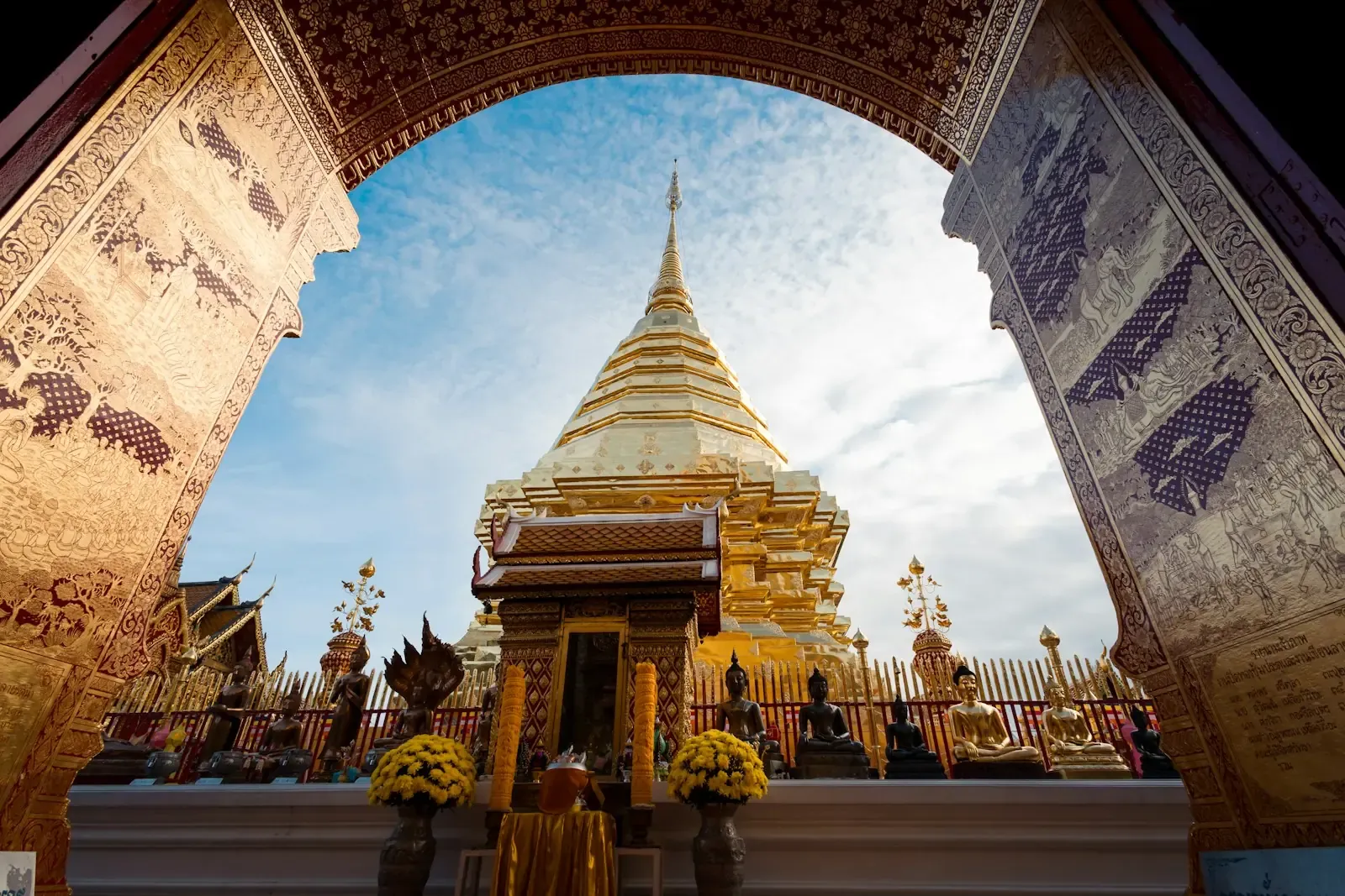 เจดีย์ทองวัดพระธาตุดอยสุเทพ มองผ่านซุ้มประตูไม้แกะสลักปิดทอง