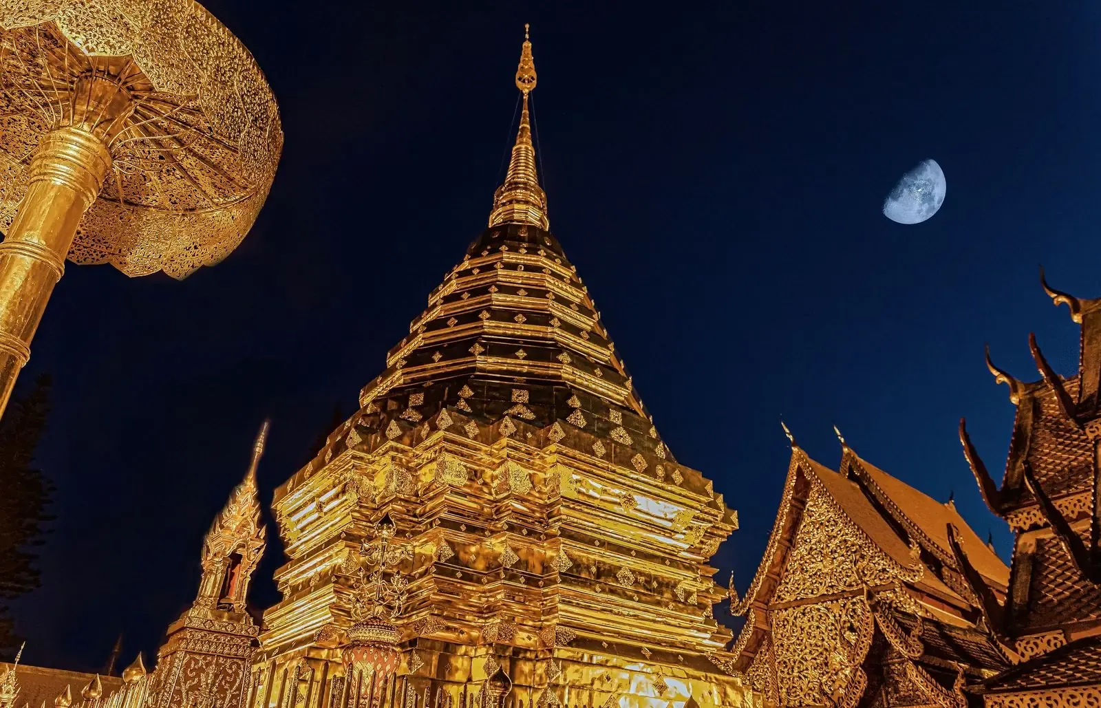 เจดีย์ทองเปิดไฟยามค่ำคืน มีพระจันทร์อยู่ด้านบน
