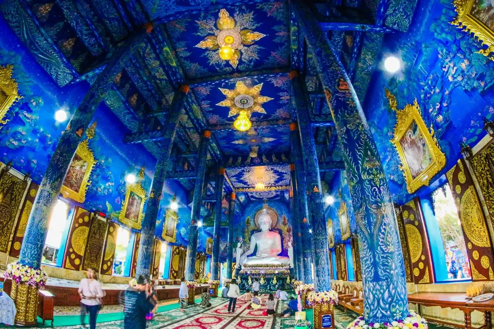Blue pillars and a white Buddha inside Wat Rong Suea Ten, the Blue Temple